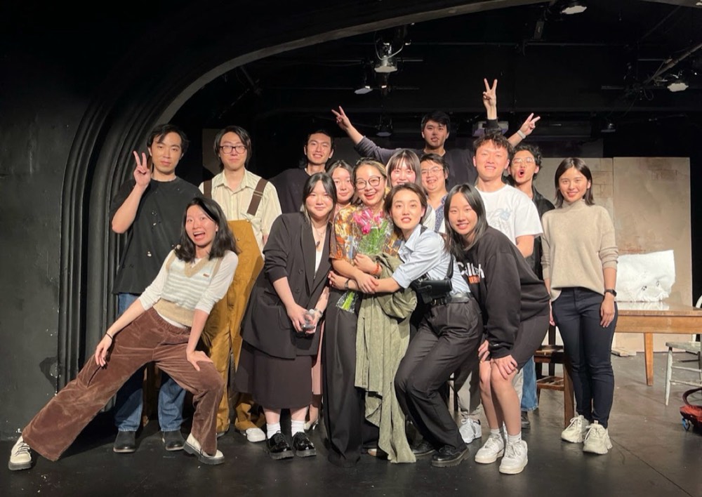 The company gathered for a group photograph in the black-box theatre after a performance.